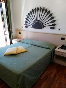a bedroom with a bed with a blue comforter at Hotel Fioroni in Bellagio
