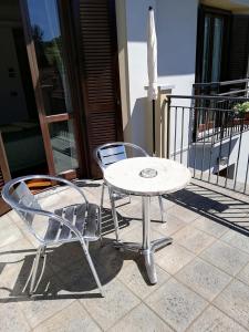 a table and chairs and an umbrella on a patio at Hotel Fioroni in Bellagio