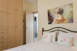 um quarto com uma cama com um quadro na parede em Mary Suites Chania em Chania