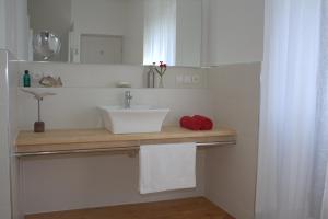 Un baño blanco con lavabo y toallas en una encimera. en La Grande Maison, en Cambieure
