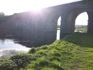 a bridge over a river with the sun shining at Matty's Pub - Apartment's in Carlow