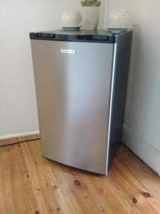 a silver refrigerator with a black top on a wooden floor at Die Hoekhuis in Cradock