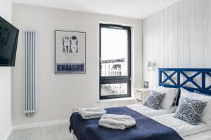a bedroom with a blue and white bed and a window at Lion Apartments - Blue Marina Premium Apartment Okrzei 21 in Sopot