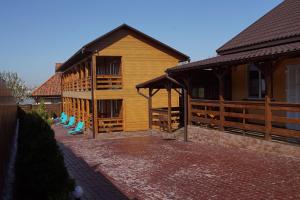 a wooden building with blue chairs in front of it at Panorama Dofinovka in Nova Dofinivka