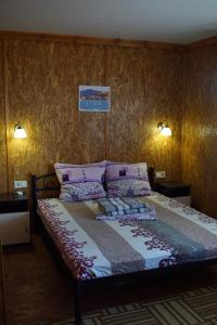 a bed in a bedroom with two lamps on the wall at Panorama Dofinovka in Nova Dofinivka