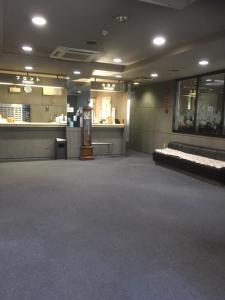 a large empty room with a couch and a bar at Hotel Tetora Kasugai Station Hotel in Kasugai