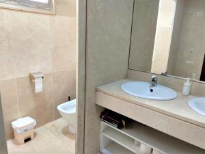 W łazience znajduje się umywalka, toaleta i lustro. w obiekcie Disfruta - Enjoy Valencia Ayuntamiento w Walencji