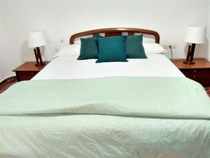 Una gran cama blanca con almohadas azules. en Disfruta - Enjoy Valencia Ayuntamiento en Valencia