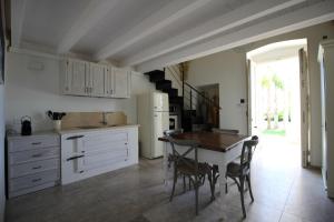 a kitchen with a table and chairs and a refrigerator at VILLA ROSA in Torre Suda