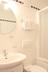ein weißes Badezimmer mit einem Waschbecken und einem Spiegel in der Unterkunft Bed & Breakfast Untermüllerhof in Meransen