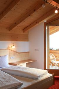 a bedroom with a bed and a desk and a window at Bed & Breakfast Untermüllerhof in Maranza