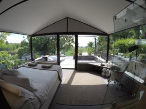 a bedroom with a large bed and a bath tub at Glass House & SPA - DCA Certified - in Terruggia