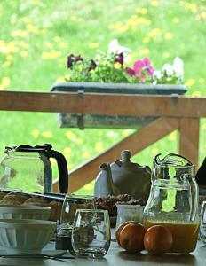 een tafel met eten en glazen en een pot bloemen bij Mas du Cresponnet in Murat