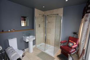a bathroom with a shower and a red chair at Bedlam House in Newquay +39 photos