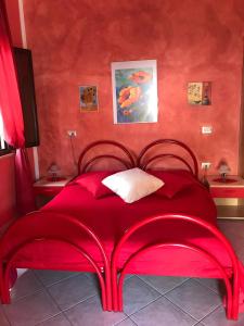 een rood bed in een kamer met rode muren bij Domu de Palla- IUN-E5167 in Bauladu