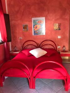 a red bed in a room with red walls at Domu de Palla- IUN-E5167 in Bauladu