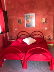 a red bed in a room with red walls at Domu de Palla- IUN-E5167 in Bauladu