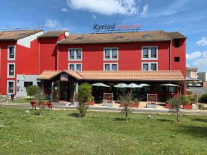 ein rotes Hotel mit einem roten Gebäude in der Unterkunft Enzo Hotels Cannes-Écluse by Kyriad Direct in Cannes-Écluse