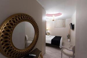 a mirror in a room with a bed and a bedroom at Pension Dafni in Nafplio