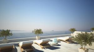 a balcony with chairs and a view of the ocean at Eleals Boutique Hotel in Perama