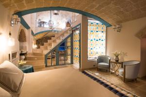a living room with a staircase and a table and chairs at Hotel Don Ferrante in Monopoli