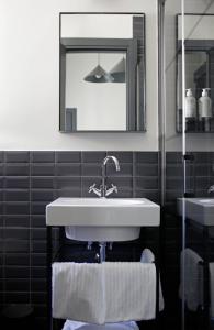 bagno con lavandino e specchio di c-hotels Club House Roma a Roma