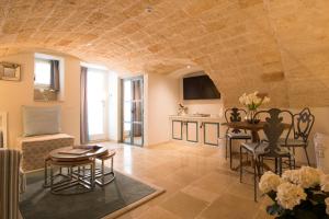 a living room with a table and chairs and a kitchen at Hotel Don Ferrante in Monopoli