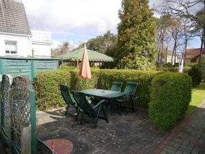 une terrasse avec une table, des chaises et un parasol dans l'établissement "Uns Klausing", à Ahlbeck