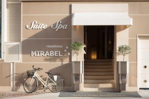 una bicicletta parcheggiata di fronte a un edificio di Suite & Spa Mirabel a Grado