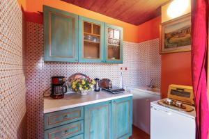 a kitchen with blue cabinets and a washing machine at Taormina Vintage Loft in Taormina