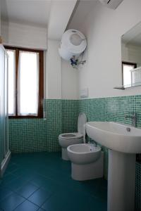 un bagno con un lavandino bianco e un water di Residenza Jennifer a Lido di Jesolo Altre 19 foto