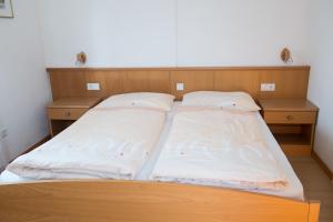 un letto con due cuscini sopra in una stanza di Ferienwohnung Pippohof ad Appiano sulla Strada del Vino