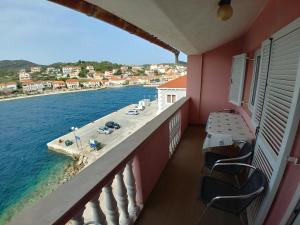 a balcony with chairs and a view of the water at Apartmani Sali Seaview in Sali