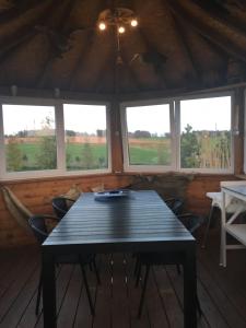 - une table en bois dans une chambre avec fenêtres dans l'établissement Svečių namelis - Pirtis, à Vydmantai