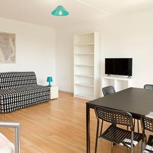 ein Wohnzimmer mit Tisch, Stühlen und Sofa in der Unterkunft Ferienwohnung Buffon in Wertheim