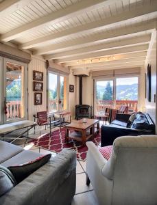 a living room with couches and a table and a fireplace at Chalet Le Renard Du Lac in Les Gets