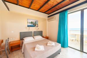 a bedroom with a bed and a view of the ocean at Olympic Suites in Rethymno