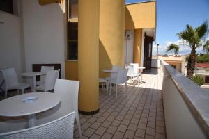 a patio with tables and chairs on a balcony at MAMA BED in Porto Cesareo