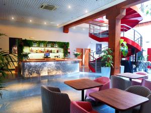 Un restaurante con mesas y sillas y un bar. en Hotel Fabrik, en Humanes de Madrid