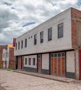 un vieux bâtiment en briques situé sur le côté d'une rue dans l'établissement Pandora hotel colca, à Chivay