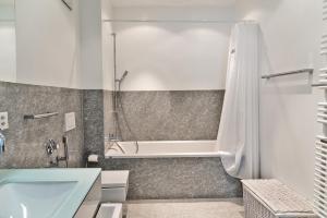 y baño con bañera y ducha. en Chesa Chalavus - St. Moritz, en St. Moritz