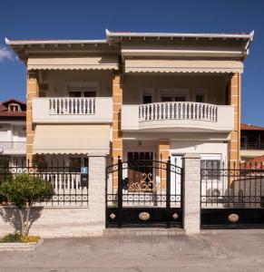 ein Haus mit einem Tor und einem Balkon in der Unterkunft Areti Apartments in Litochoro