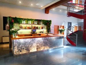 eine Bar in einem Raum mit einer Theke voller Blumen in der Unterkunft Hotel Fabrik in Humanes de Madrid