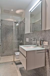 a bathroom with a sink and a shower at Chesa Chalavus - St. Moritz in St. Moritz