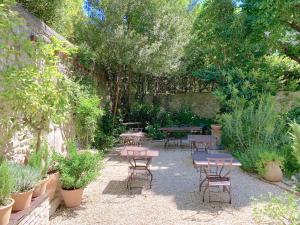 a patio with tables and chairs in a garden at Le Clos Saluces in Avignon