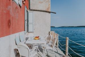 a table and chairs on a boat on the water at Luxury Seafront Palazzo in Rovinj