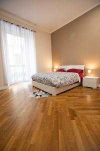 um quarto com uma cama e piso em madeira em Privilege Chiaia by Dimorra em Nápoles