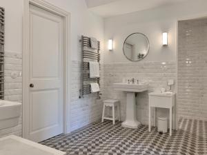 a white bathroom with a sink and a mirror at Le Clos Saluces in Avignon
