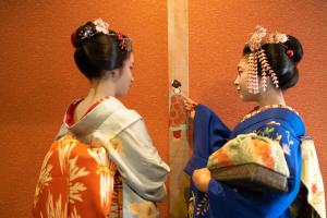 dos estatuas de mujeres en kimonos mirándose en un espejo en Stay SAKURA Kyoto Kiyomizu Gojo, en Kioto