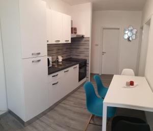 a kitchen with white cabinets and a table and chairs at Apartment Vesna in Novalja +8 photos